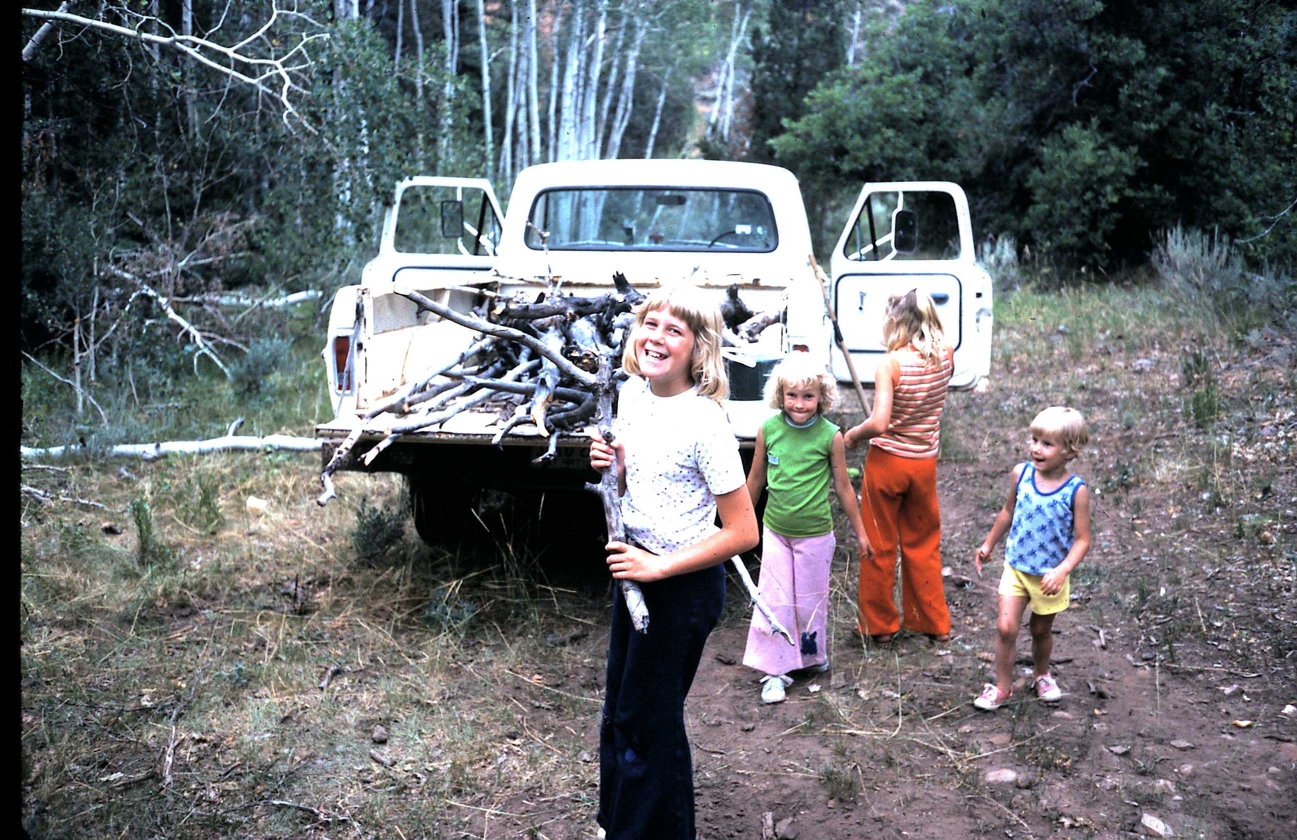 My sisters collecting bigger limbs for firewood.